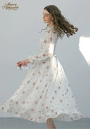 Floral midi dress with long sleeves, ruffled neckline, and full tiered skirt