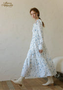 Blue floral tiered maxi dress with long sleeves and layered skirt, profile view.
