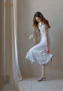 White lace midi dress with short sleeves and scalloped ruffle hem, side view