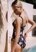 Floral black one-piece swimsuit shown from the side with low back and thin straps