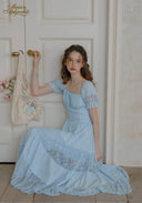 Light blue lace tiered dress with square neckline and puff sleeves, seated pose.