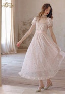 Light pink floral tea dress, short puff sleeves and lace yoke, gathered tiered skirt; standing pose.