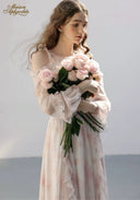 Floral tiered dress in pale pink with ruffled neckline and sleeves, bouquet close view