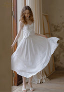White lace midi dress with thin straps, gathered waist, flared skirt in soft folds