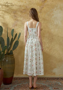 Back view of floral printed cotton suspender midi dress with open back and straps