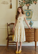Off-white lace embroidered dress with square neckline, short ruffled sleeves, and tiered hem.