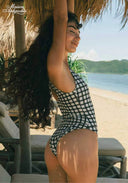 Black-and-white checkered one-piece swimsuit with scoop neckline and thin straps, side view.