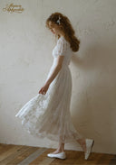 White lace dress with puff sleeves and square neckline, fitted bodice and full skirt.
