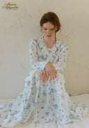 Blue floral tiered maxi dress with long sleeves and gathered waist, close-up.
