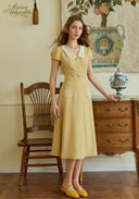 Yellow embroidered midi dress with short sleeves, peter pan collar, and button front
