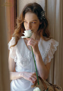 White lace V-neck dress with scalloped trim and short ruffled sleeves