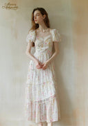 Woman wearing a floral dress against a plain background