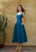 Blue linen suspender dress with square neckline and flared pleated midi skirt