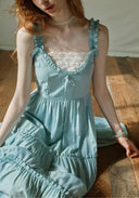 Light blue dress bodice with lace-trim square neckline, center bow, tiered ruffle skirt