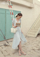 Blue Celeste floral dress with V-neck and side slit, holding book-style package