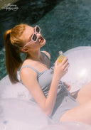 Light blue one-piece swimsuit with lace-up front and thin tie straps, worn in water