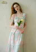 Pastel floral dress with ruffle trim at neckline, puff sleeves, and tiered skirt