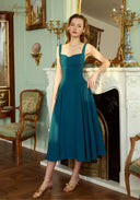Teal blue suspender midi dress with square neckline and full pleated skirt, front view.