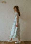 Light blue floral midi dress with puff sleeves and elastic waist, standing profile