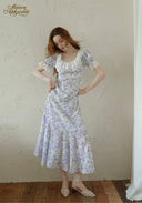 Lavender floral midi dress with square neckline and puff sleeves, front view with hands on hips.