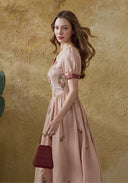 Pink linen maxi dress with burgundy cap sleeves and floral embroidery, side view