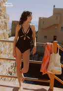 Black cut-out one-piece swimsuit with ring halter straps and oval center cut-out, side