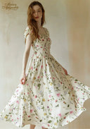 Floral midi dress with short puff sleeves and sweeping flared skirt, white background
