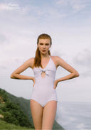 White one-piece swimsuit with bow at chest, halter neckline, and sparkle dot pattern.