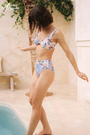 Back view of floral printed bikini set with thin straps and ruched waist in light blue